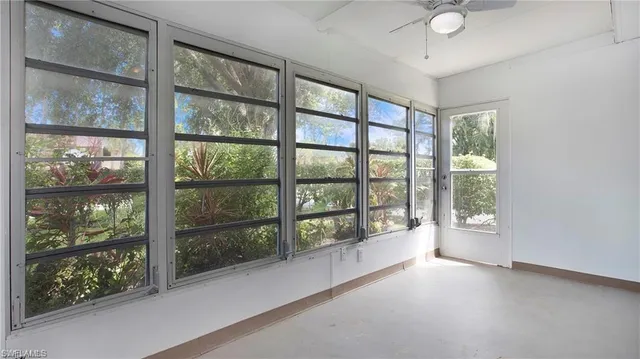 an empty room with a window and a fan