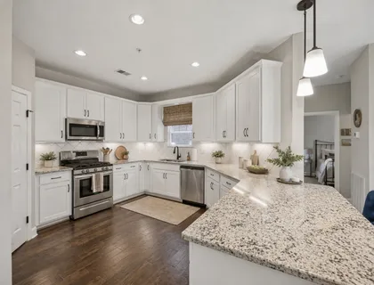 a kitchen with stainless steel appliances granite countertop sink stove top oven and refrigerator