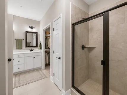 a bathroom with a double vanity sink mirror and shower