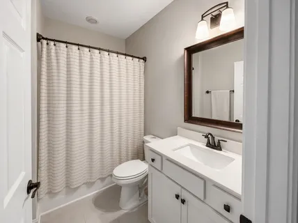 a bathroom with a sink a toilet and mirror