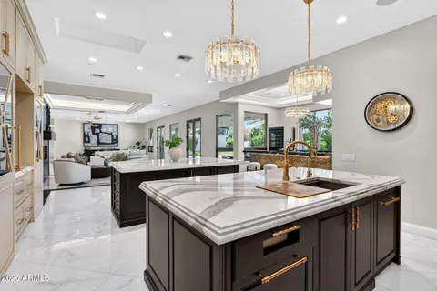 a kitchen with a dining table chairs and chandelier