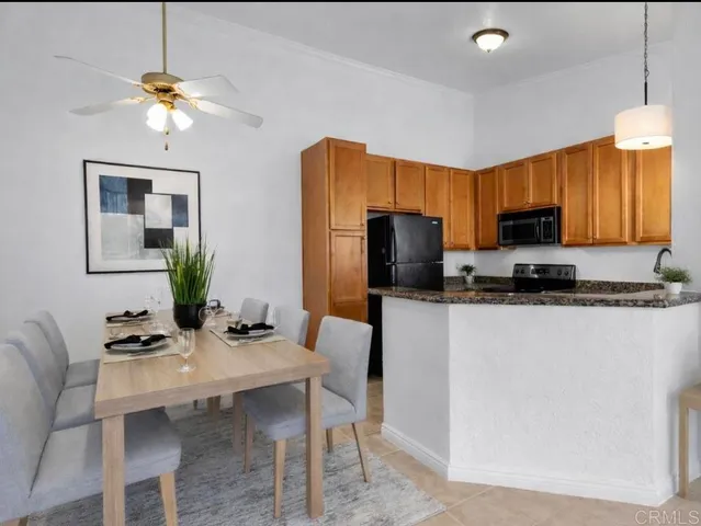 a kitchen with stainless steel appliances granite countertop a refrigerator a stove a sink dishwasher a dining table and chairs with wooden floor