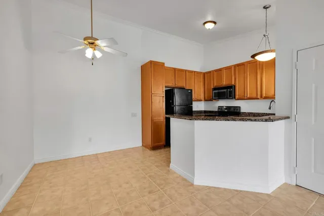 a view of kitchen with stainless steel appliances granite countertop cabinets and refrigerator