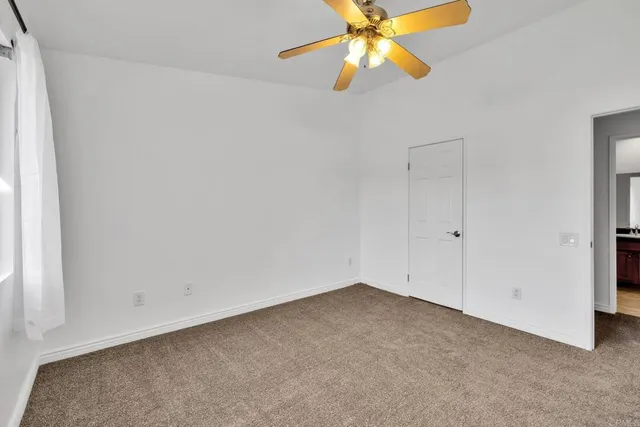 an empty room with a fan and a fan