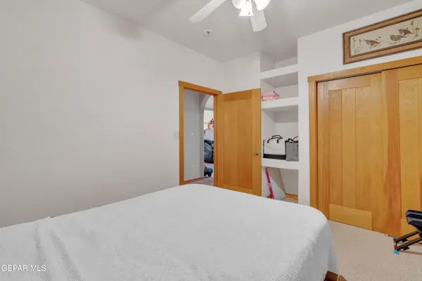 a bedroom with a large bed and a chandelier