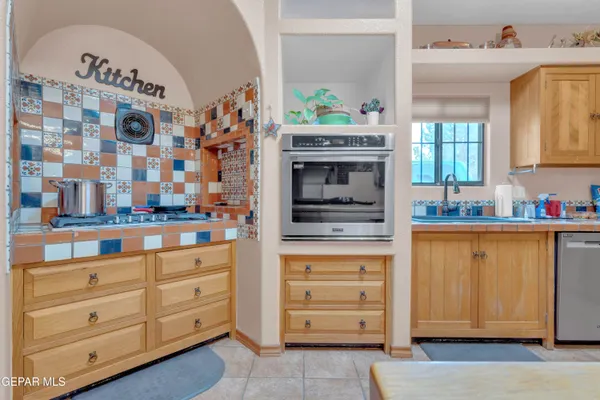 a kitchen with granite countertop white cabinets and stainless steel appliances