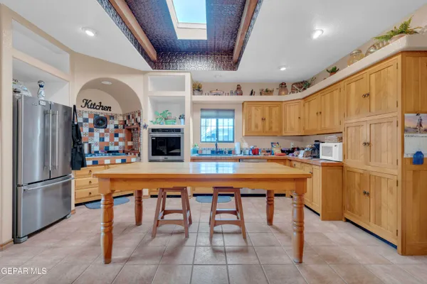 a kitchen with stainless steel appliances granite countertop a refrigerator and a stove top oven