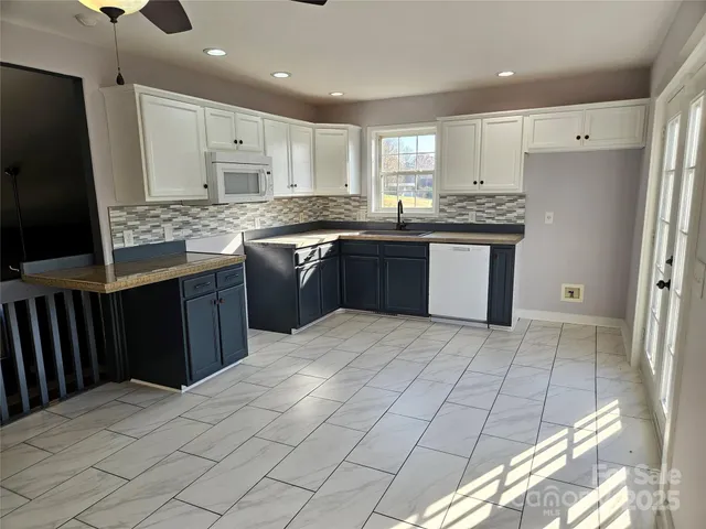 a kitchen with stainless steel appliances granite countertop a refrigerator sink and cabinets