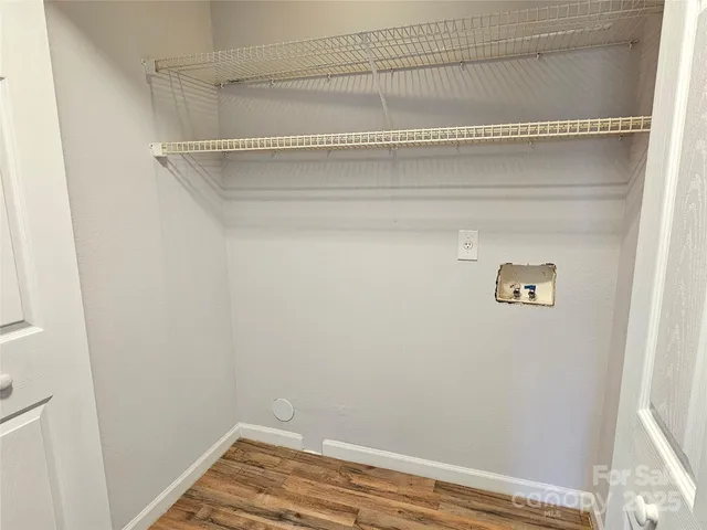 a view of a closet with wooden floor