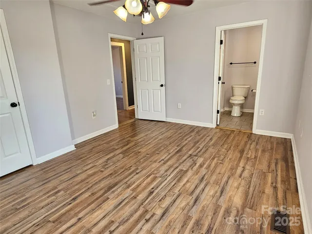 a view of a room with wooden floor and a ceiling fan