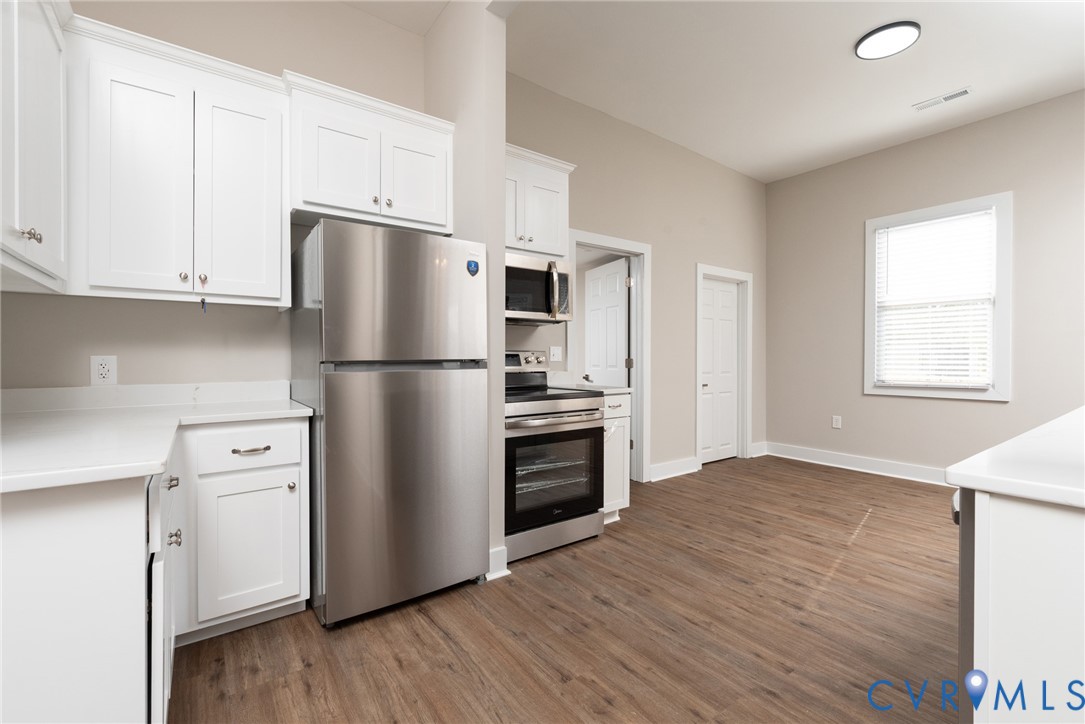 9800 Golf Course Drive Disputanta, VA 23842 - Photo 4 of 19 a kitchen with granite countertop stainless steel appliances a refrigerator a stove a microwave and cabinets