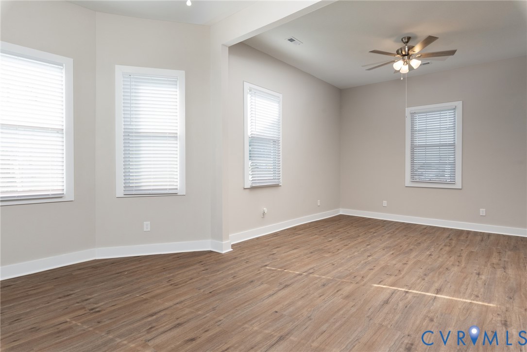 9800 Golf Course Drive Disputanta, VA 23842 - Photo 8 of 19 an empty room with wooden floor and windows