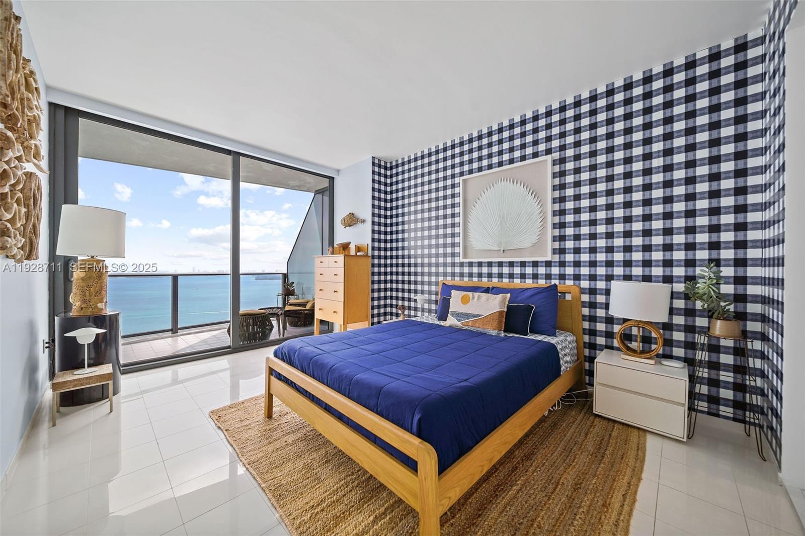 460 Northeast 28th Street, Unit 3904 Miami, FL 33137 - Photo 16 of 54 a bedroom with a bed and a lamp next to a large window