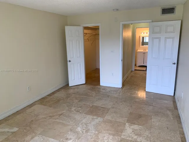 an empty room with closet and mirror
