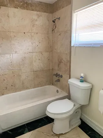 a bathroom with a toilet a sink and bathtub