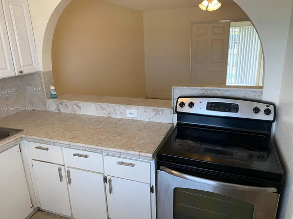 a stove top oven sitting inside of a kitchen