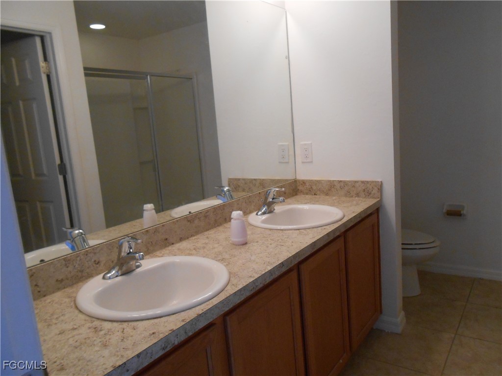 154 Shadowview Court Lehigh Acres, FL 33974 - Photo 20 of 40 a bathroom with a granite countertop sink and a mirror