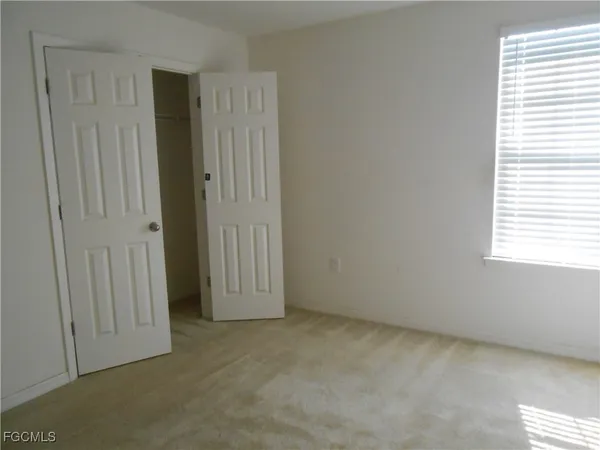 an empty room with windows and closet