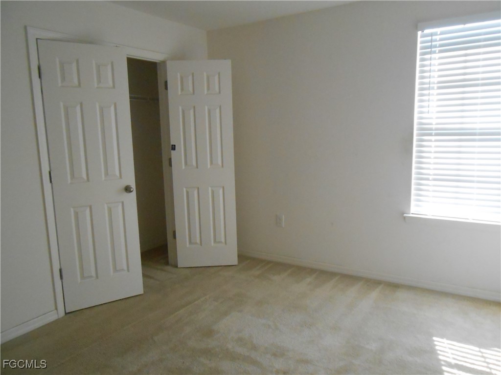 154 Shadowview Court Lehigh Acres, FL 33974 - Photo 27 of 40 an empty room with windows and closet