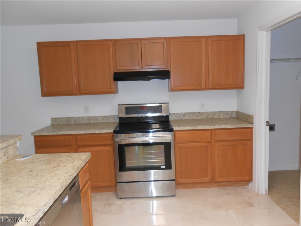 154 Shadowview Court Lehigh Acres, FL 33974 - Photo 5 of 40 a kitchen with granite countertop a stove and a sink
