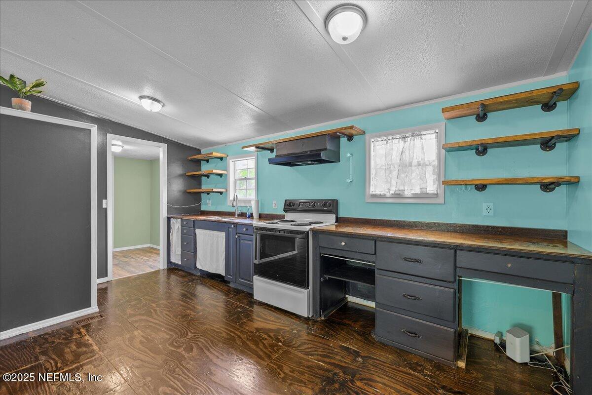 301 Kitty Avenue Interlachen, FL 32148 - Photo 12 of 23 a kitchen with stainless steel appliances kitchen island granite countertop a refrigerator and a stove
