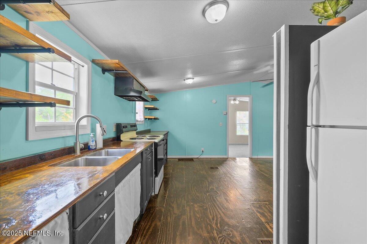 301 Kitty Avenue Interlachen, FL 32148 - Photo 13 of 23 a kitchen with granite countertop a sink and a refrigerator