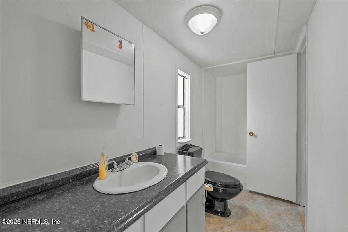 301 Kitty Avenue Interlachen, FL 32148 - Photo 16 of 23 a bathroom with a granite countertop sink and a mirror