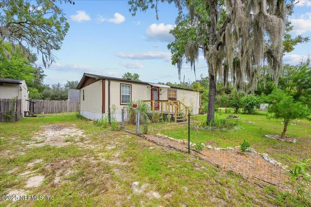 a view of a house with backyard and a tree