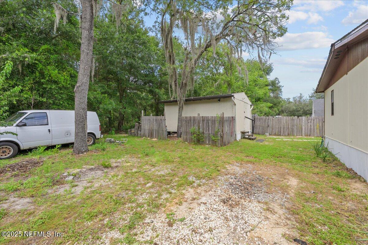 301 Kitty Avenue Interlachen, FL 32148 - Photo 4 of 23 a backyard of a house with plants and large tree