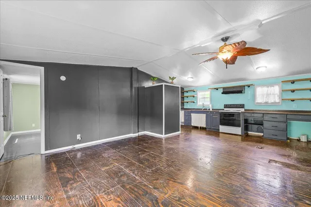 a view of a livingroom with furniture and a ceiling fan