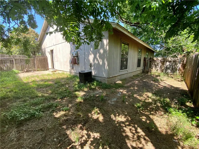 a view of a yard in front of a house with large tree