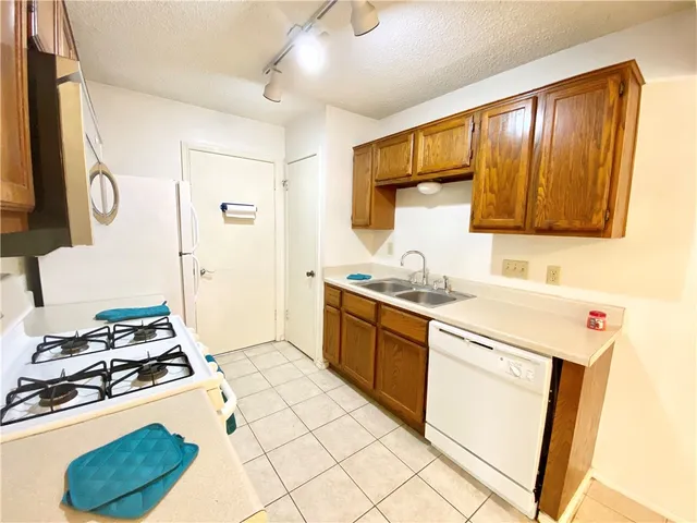 a kitchen with a stove a sink and a refrigerator