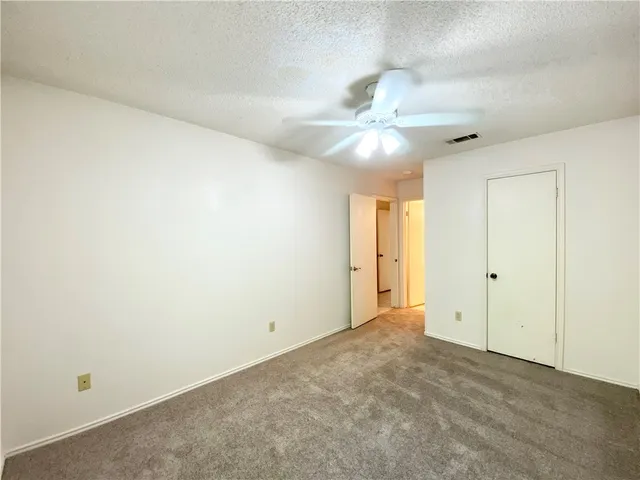 an empty room with a ceiling fan and a window