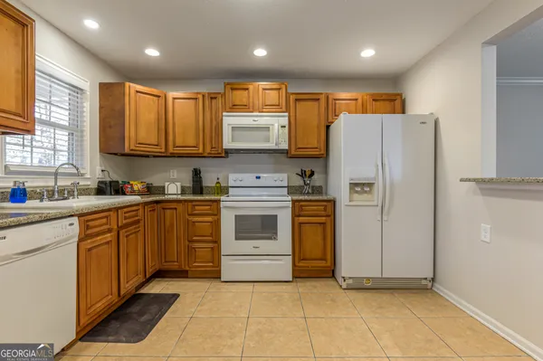 a kitchen with stainless steel appliances granite countertop a refrigerator sink and cabinets