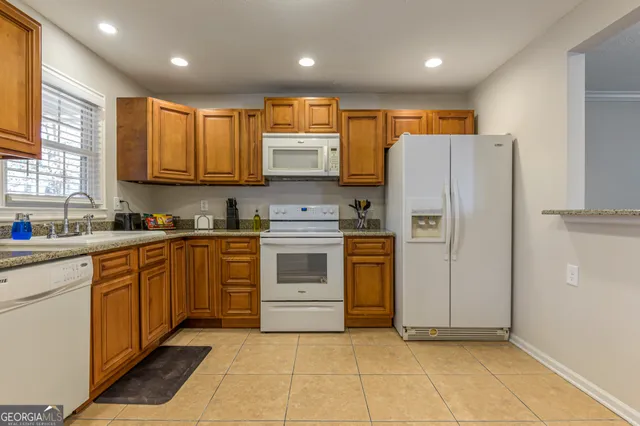 a kitchen with stainless steel appliances granite countertop a refrigerator sink and cabinets