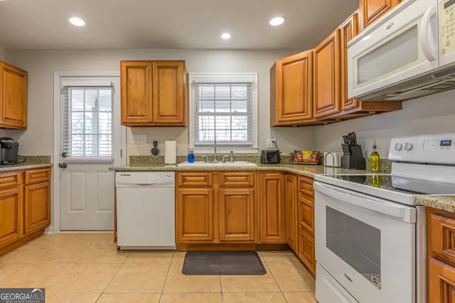 a kitchen with granite countertop cabinets stainless steel appliances a sink and a window