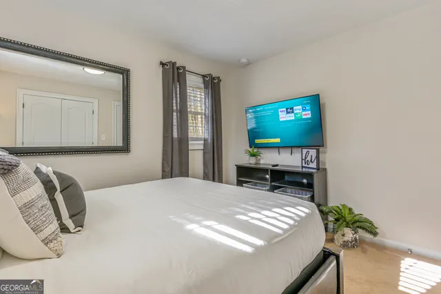 a bedroom with a bed and a flat screen tv
