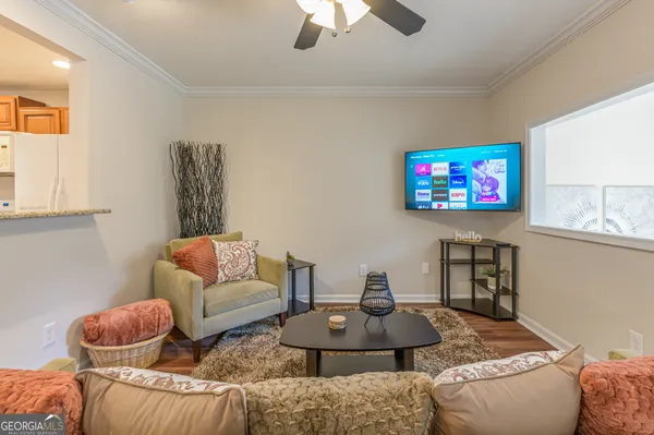 a living room with furniture a rug and a flat screen tv