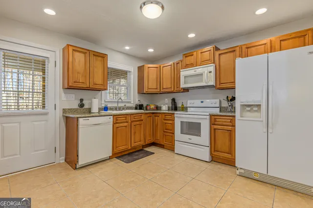 a kitchen with stainless steel appliances granite countertop a refrigerator sink and cabinets