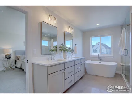 a spacious bathroom with a double vanity sink mirror and bathtub