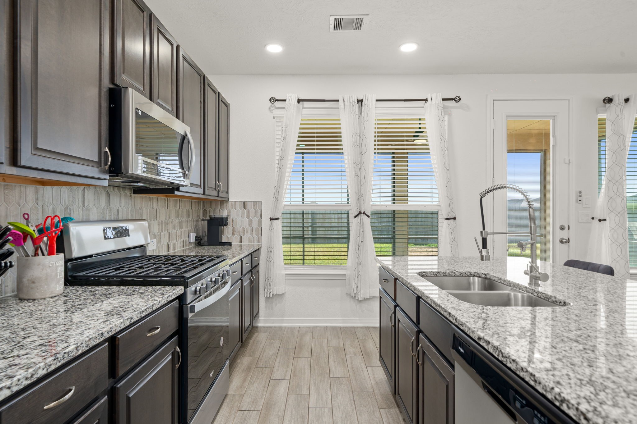 20811 Filbert Lane Katy, TX 77449 - Photo 11 of 43 a kitchen with stainless steel appliances granite countertop a sink stove and cabinets