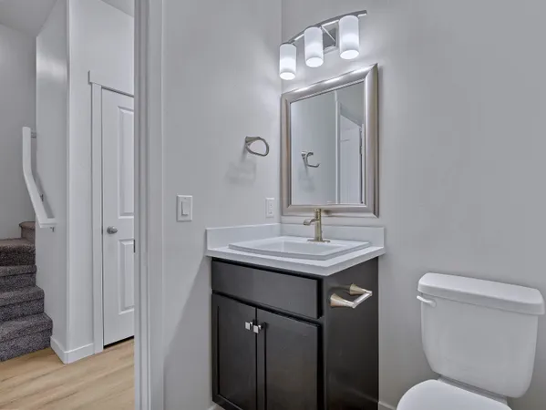 a bathroom with a toilet a sink and mirror
