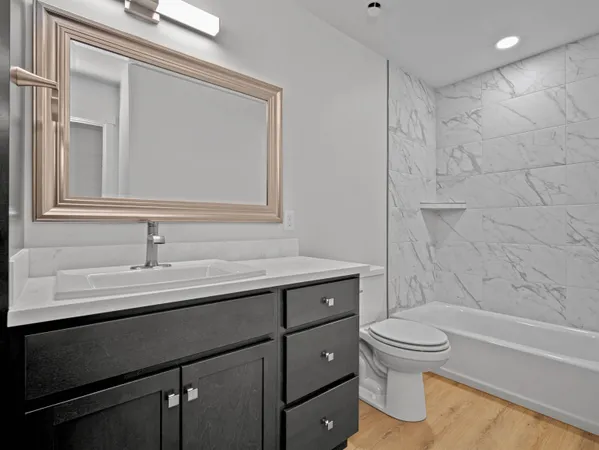 a bathroom with a sink a toilet and shower