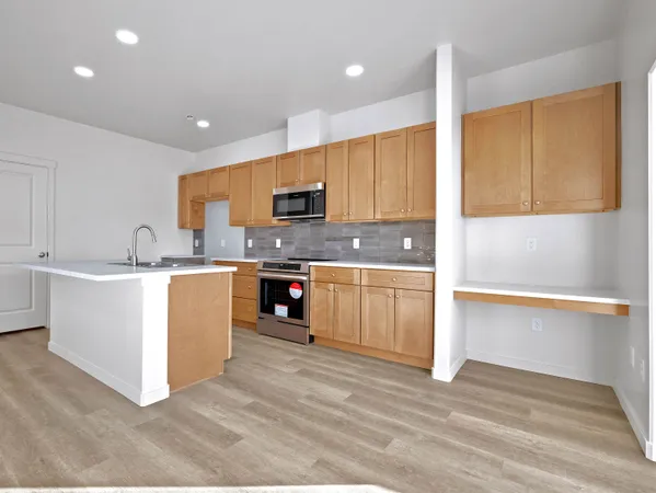 a kitchen with a sink a counter top space cabinets and stainless steel appliances