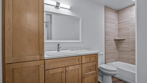 a bathroom with a granite countertop toilet sink and mirror