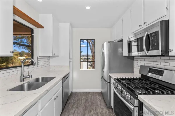 a kitchen with stainless steel appliances granite countertop a sink stove oven and granite counter tops