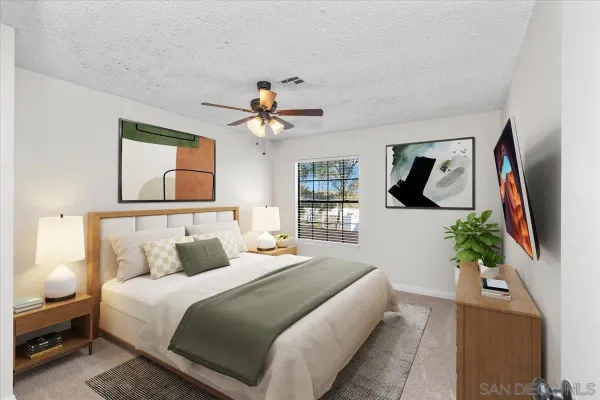 a bedroom with a large bed and a chandelier