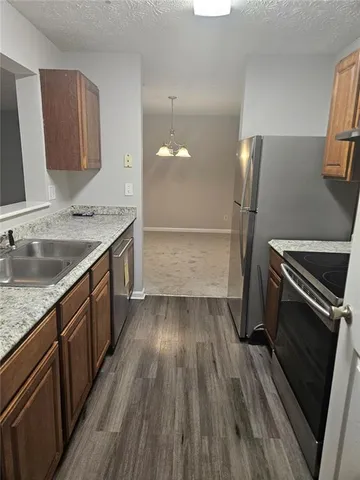 a kitchen with a sink wooden floor and stainless steel appliances