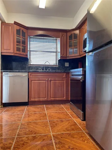 a kitchen with stainless steel appliances granite countertop a refrigerator and cabinets