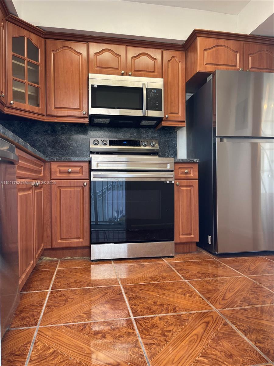 7328 Southwest 82nd Street, Unit B213 Miami, FL 33143 - Photo 7 of 22 a kitchen with stainless steel appliances granite countertop a refrigerator stove and microwave